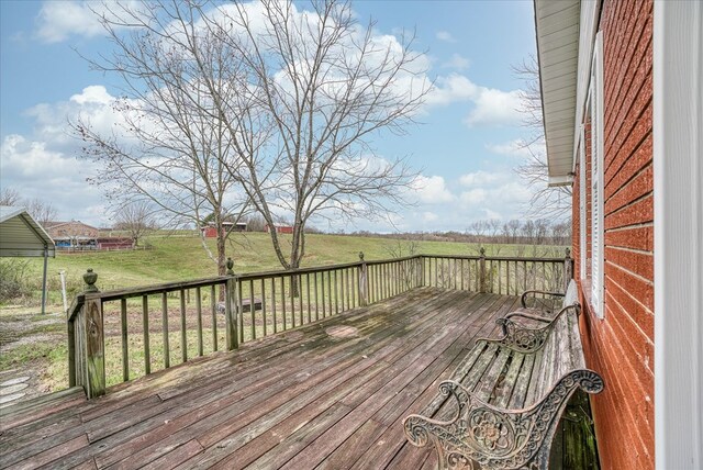 wooden deck with a yard and a rural view