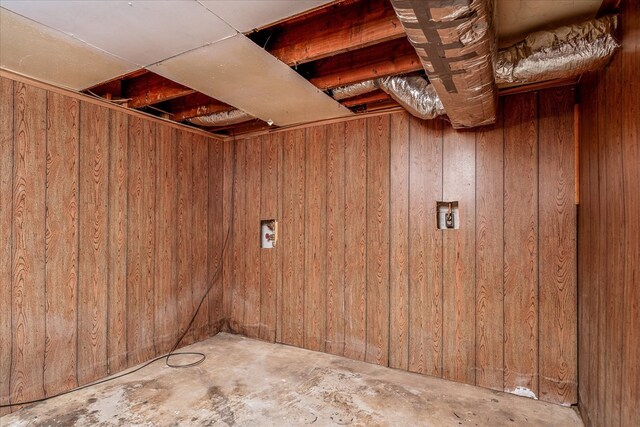 finished basement featuring wooden walls