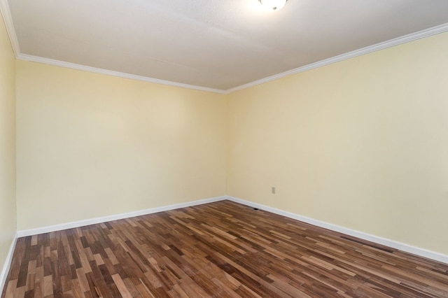 spare room with dark wood-style floors, crown molding, and baseboards