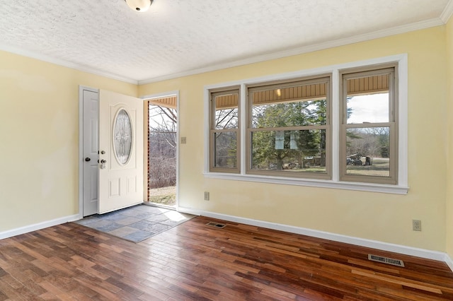 entryway with dark wood-style floors, visible vents, crown molding, and baseboards