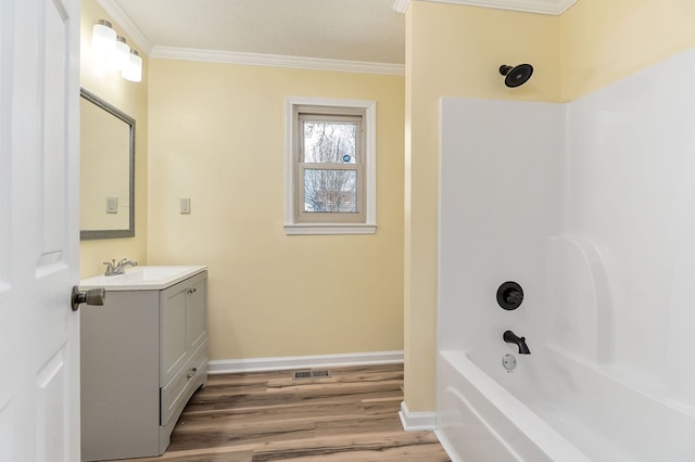 bathroom featuring crown molding, shower / bath combination, vanity, wood finished floors, and baseboards