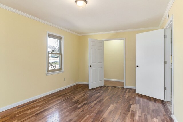 unfurnished bedroom featuring dark wood-style floors, baseboards, and ornamental molding