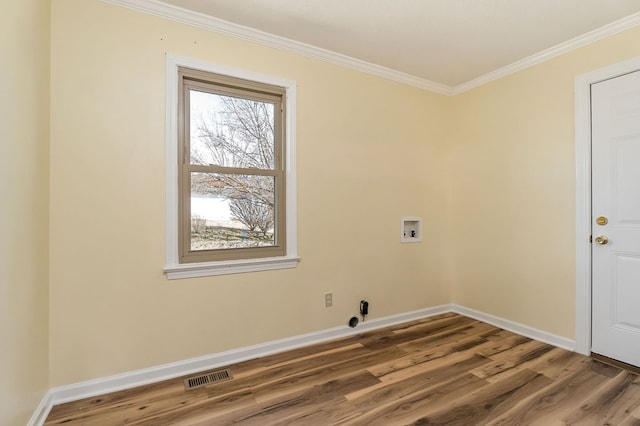 clothes washing area with hookup for a washing machine, visible vents, wood finished floors, laundry area, and baseboards