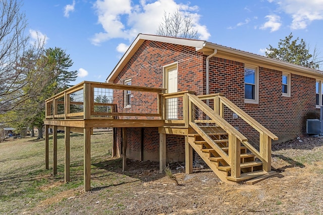 rear view of house with stairway, brick siding, central AC, and a wooden deck