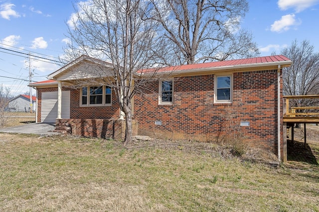 view of home's exterior featuring crawl space, metal roof, a lawn, and brick siding