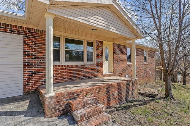 doorway to property with brick siding