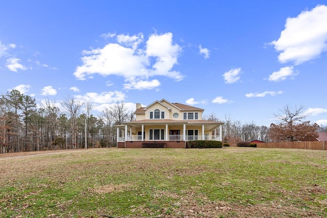 view of front of home featuring a chimney, fence, a porch, and a front yard