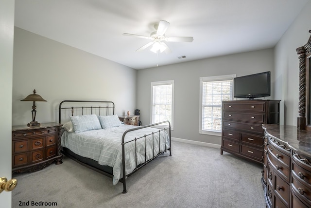 bedroom with a ceiling fan, light colored carpet, visible vents, and baseboards