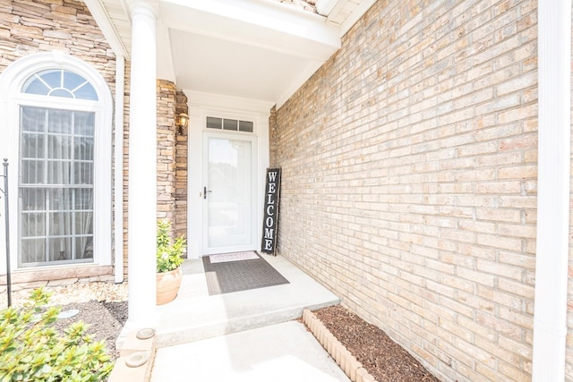 entrance to property featuring stone siding and brick siding