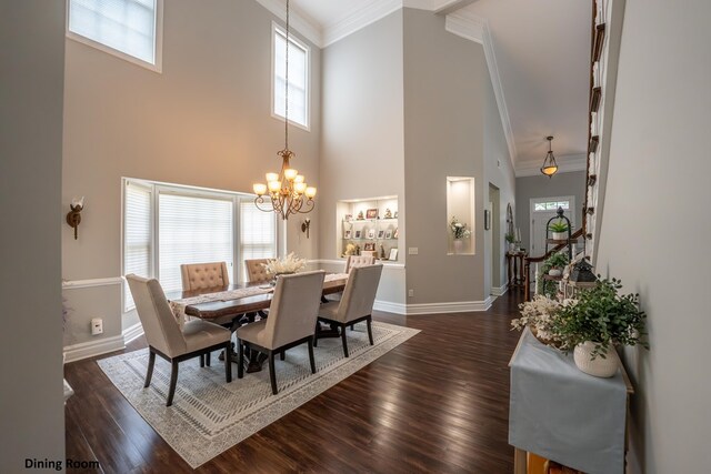 dining area featuring ornamental molding, dark wood finished floors, baseboards, and an inviting chandelier