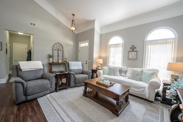 living room with baseboards, crown molding, visible vents, and wood finished floors