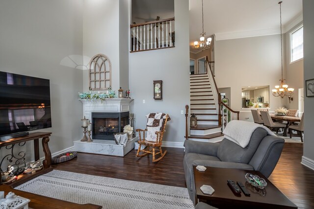 living room with dark wood-style flooring, a fireplace, a notable chandelier, and a high ceiling