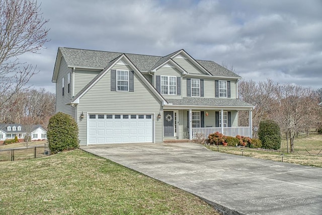 traditional home with roof with shingles, a porch, concrete driveway, fence, and a front lawn