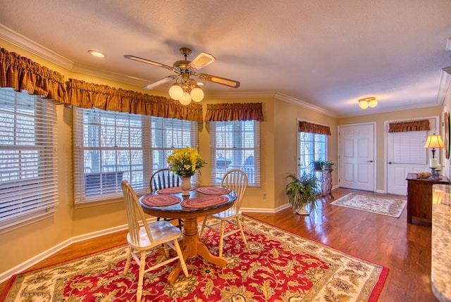 dining room with crown molding, a textured ceiling, and wood finished floors