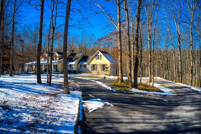 view of street with sidewalks, a forest view, and curbs