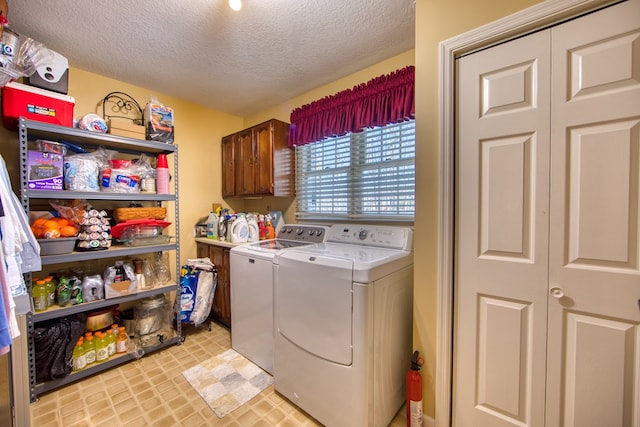 laundry room featuring cabinet space, a textured ceiling, and independent washer and dryer