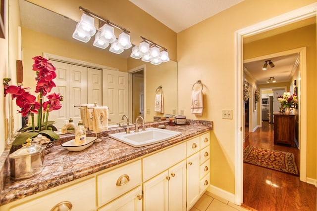 bathroom with vanity, baseboards, and tile patterned floors