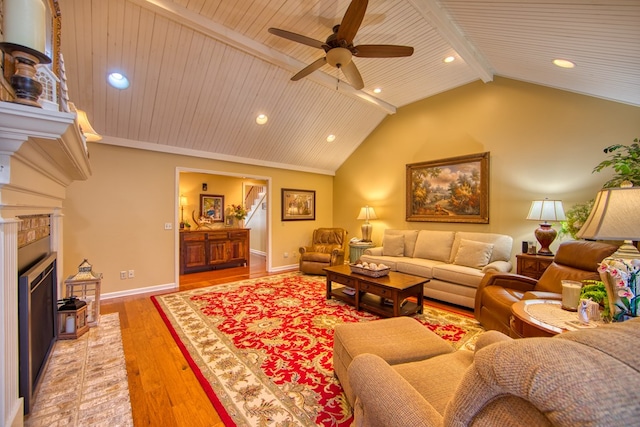 living area with baseboards, light wood-style flooring, vaulted ceiling with beams, a fireplace, and recessed lighting