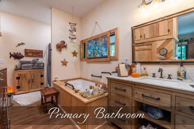 full bathroom featuring a garden tub, wood finished floors, and vanity