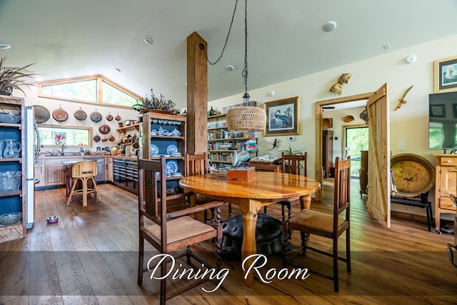 dining space featuring lofted ceiling and dark wood-style floors