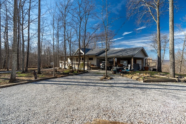 view of front of house with gravel driveway and metal roof