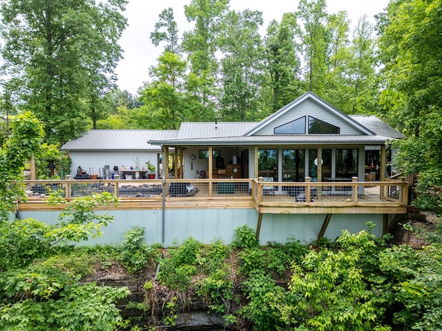 back of property featuring metal roof and a wooden deck