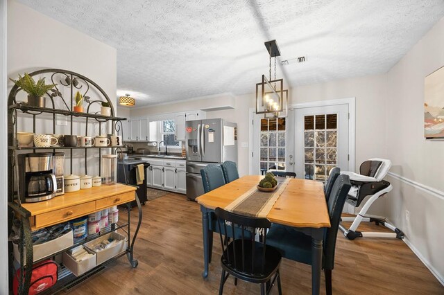 dining room featuring baseboards, visible vents, dark wood-type flooring, a textured ceiling, and french doors