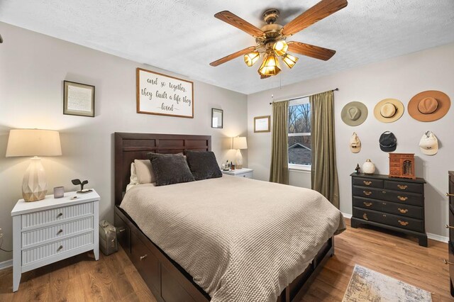 bedroom featuring a textured ceiling, ceiling fan, wood finished floors, and baseboards