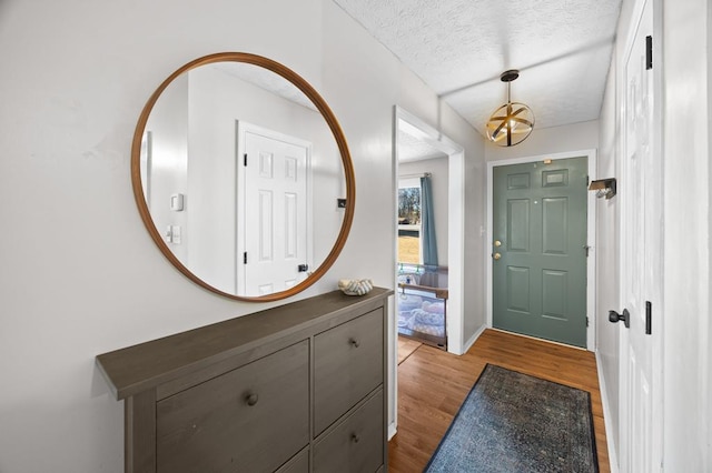 entrance foyer with light wood-style floors and a textured ceiling