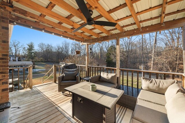 wooden deck featuring an outdoor living space and a ceiling fan