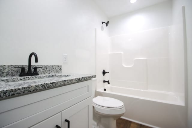 bathroom with toilet, vanity, shower / tub combination, and wood finished floors