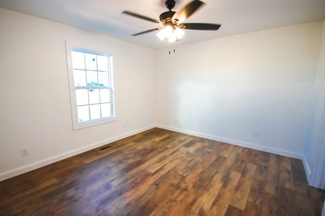 empty room with a ceiling fan, visible vents, baseboards, and dark wood-style flooring