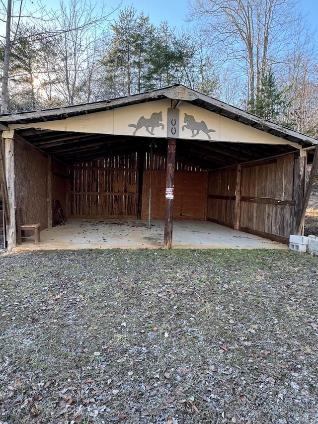 view of side of home featuring driveway, an outbuilding, and an outdoor structure