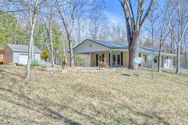 ranch-style house featuring an outbuilding, a garage, brick siding, french doors, and a front yard