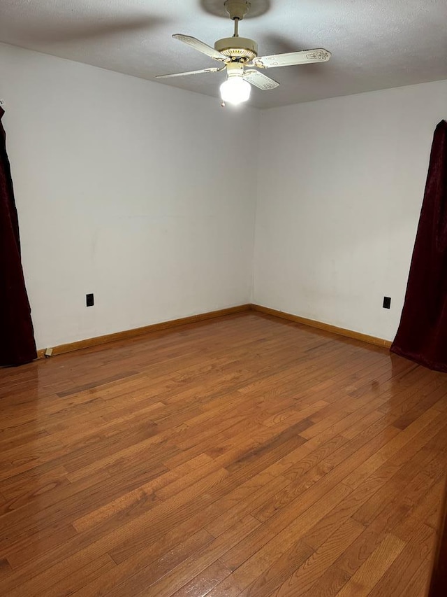 empty room with light wood finished floors, ceiling fan, baseboards, and a textured ceiling