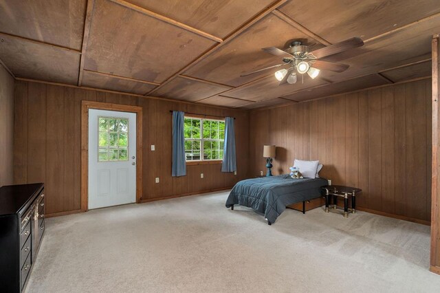 bedroom with baseboards, wooden walls, wood ceiling, and light colored carpet