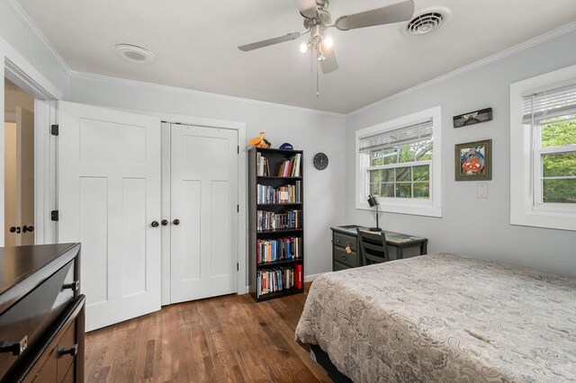 bedroom with visible vents, ceiling fan, ornamental molding, dark wood-style flooring, and a closet