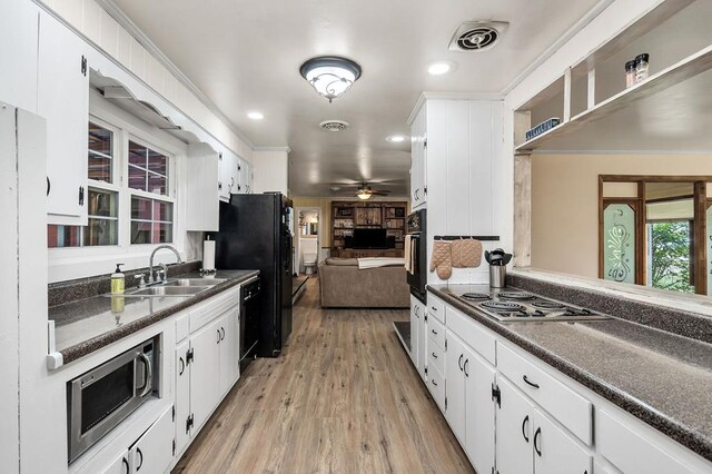 kitchen featuring dark countertops, black appliances, visible vents, and a sink