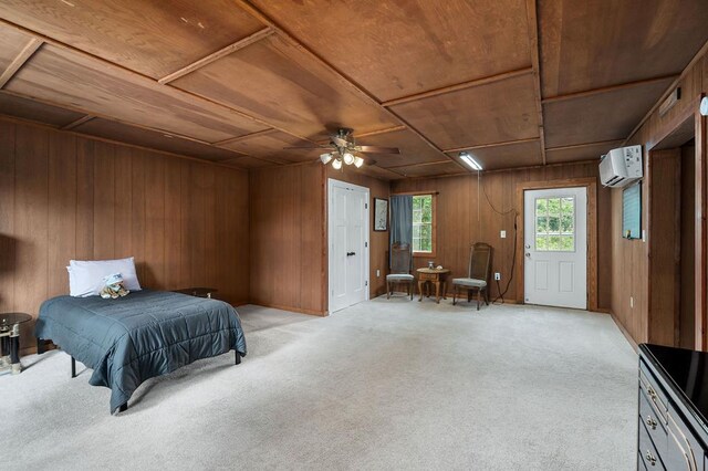 bedroom with light carpet, a wall unit AC, and wooden walls