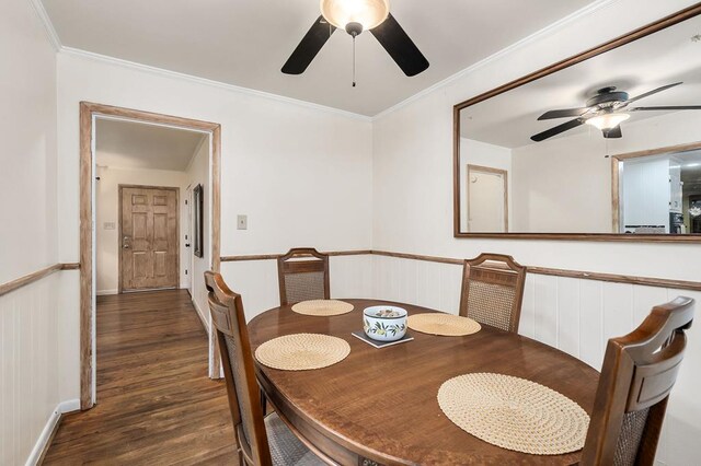 dining room featuring dark wood-style floors, crown molding, baseboards, and ceiling fan