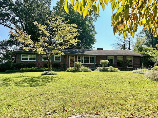 ranch-style house with brick siding and a front yard