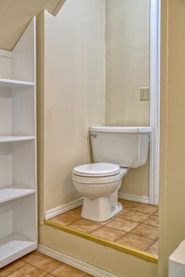 bathroom with tile patterned floors, toilet, and baseboards