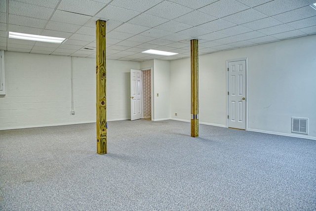 finished basement featuring visible vents, a paneled ceiling, baseboards, and carpet flooring