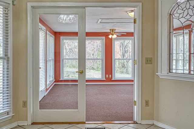 doorway to outside with tile patterned floors, carpet flooring, baseboards, and ceiling fan