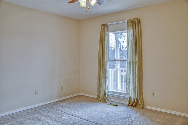 empty room featuring plenty of natural light, baseboards, a ceiling fan, and carpet floors