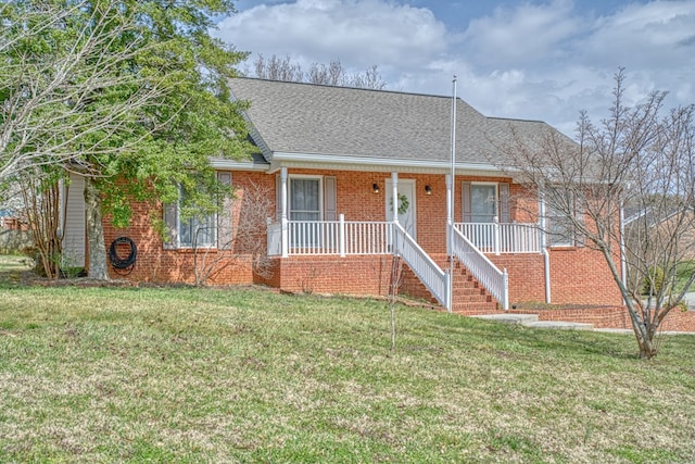 ranch-style house featuring brick siding, covered porch, a shingled roof, and a front lawn