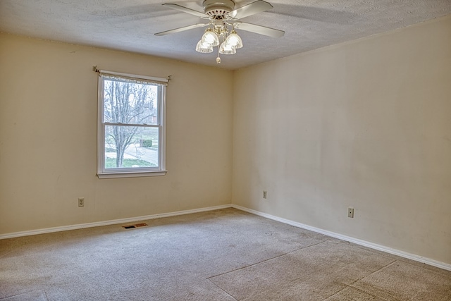 spare room with ceiling fan, carpet, visible vents, and a textured ceiling