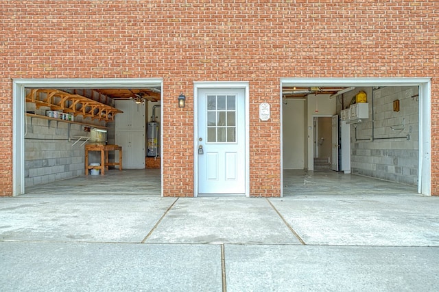 garage with gas water heater and driveway