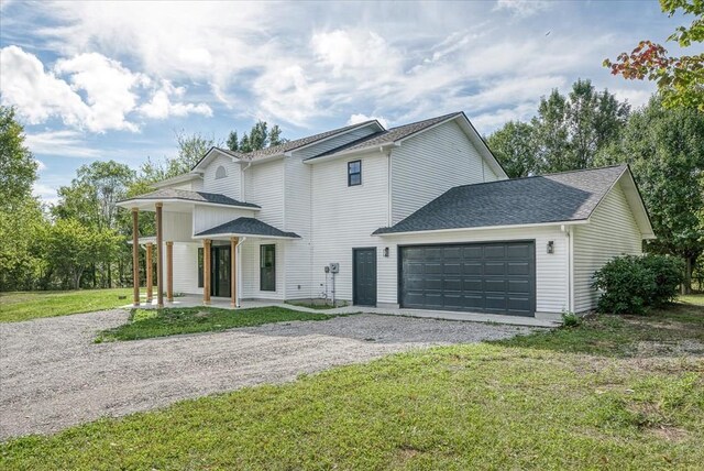 view of front of property with gravel driveway, a garage, a front lawn, and roof with shingles