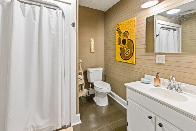 bathroom with toilet, tile patterned flooring, wooden walls, and vanity